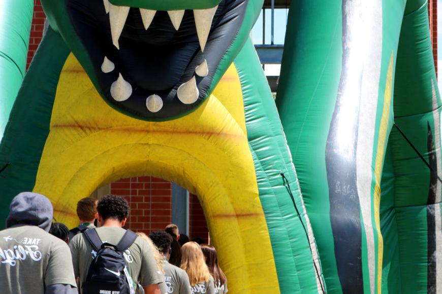 走向集会的学生队伍 through inflatable dragon tunnel